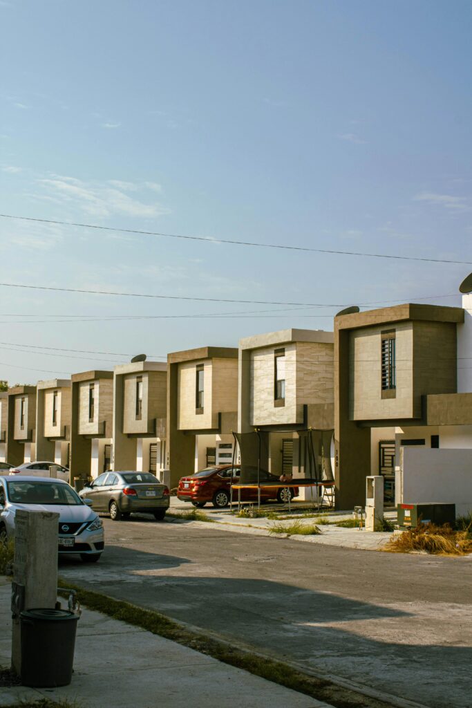 A view of modern suburban houses with parked cars on a sunny day in Monterrey, Mexico.